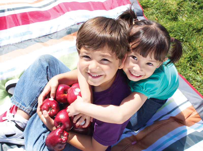 A boy and girl with apples.