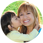 Daughter kissing her smiling mother.